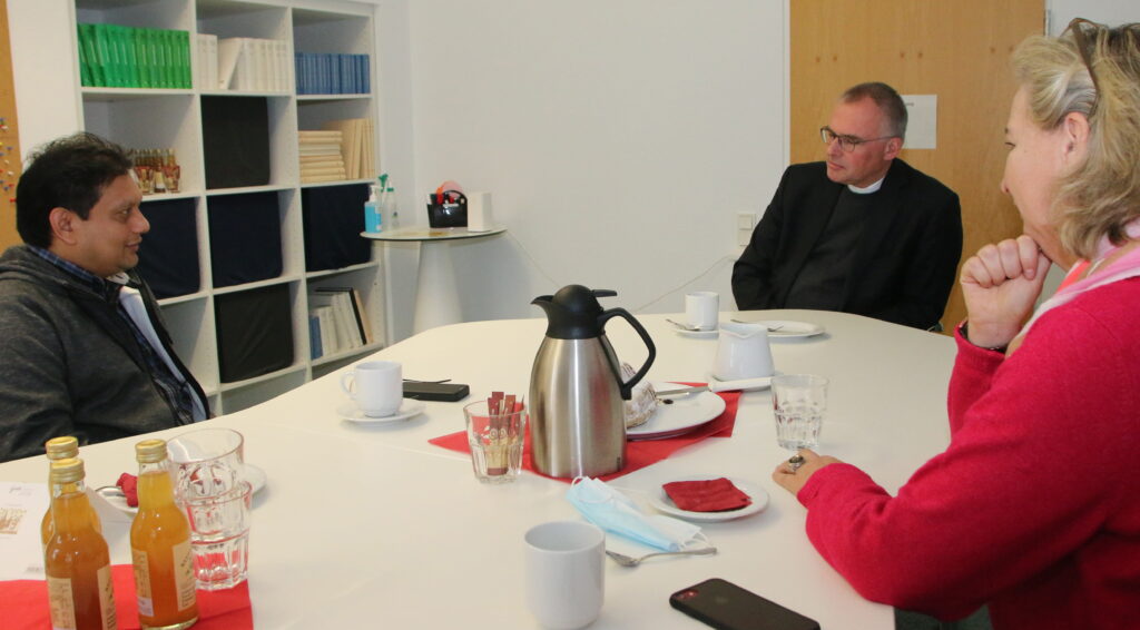 Pfarrer Jiji Vattapparambil, der Vorsitzende des Diözesancaritasverbandes Münster, Christian Schmitt, und Caritas-Mitarbeiterin Christiane Kröger
